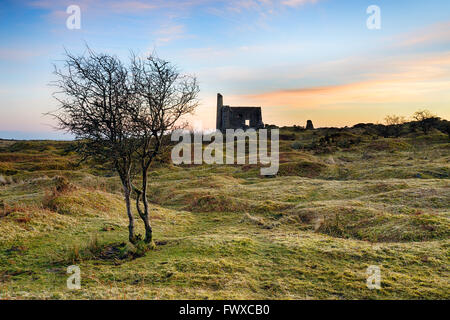 Sonnenuntergang über einer alten Ruine Maschinenhaus aus den Tagen der Kupfergewinnung an Schergen auf Bodmin Moor in Cornwall Stockfoto