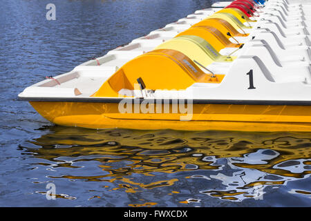 Linie von Tretbooten auf einem Pier - Reihe von Booten Stockfoto