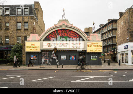 Ein Mann auf einer Leiter zeigt heutige Inserate vor dem Bildschirm auf den grünen Kino am Upper Street, Islington, London, UK Stockfoto