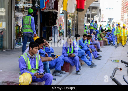 Katar, Doha, Musheireb, Bau-Boom für die FIFA-Fußball-Welt WM 2022, der Bau erfolgt durch Wanderarbeiter aus aller Welt, Mittag auf der Straße / KATAR, Doha, Bauboom Fuer Die FIFA Fußball WM 2022 / KATAR, Doha, Bauboom Fuer Die FIFA Fußball WM 2022, Abrissviertel Musheireb, Auf den Baustellen Fuer Neubauten Schuften Gastarbeiter aus Aller Welt, Arbeiter Bei Mittagspause Auf der Straße Stockfoto