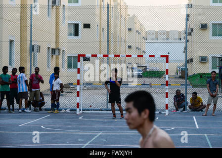 Katar, Doha, industrielle Komplex, Gehäuse Lager für Wanderarbeitnehmer, außerhalb der Stadt, Sport, Arbeitnehmer aus Vietnam und den Philippinen spielen Fußball am Sportplatz Stockfoto