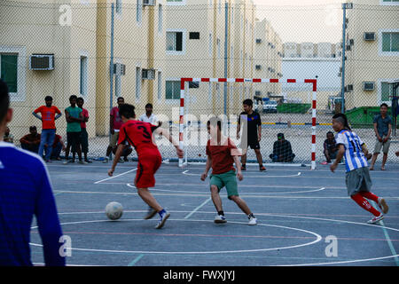 Katar, Doha, industrielle Komplex, Gehäuse Lager für Wanderarbeitnehmer, außerhalb der Stadt, Sport, Arbeitnehmer aus Vietnam und den Philippinen spielen Fußball am Sportplatz Stockfoto