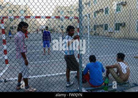 Katar, Doha, industrielle Komplex, Gehäuse Lager für Wanderarbeitnehmer, außerhalb der Stadt, Sport, Arbeitnehmer aus Vietnam und den Philippinen spielen Fußball am Sportplatz Stockfoto