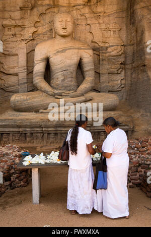 Sri Lanka, Polonnaruwa, Gal Vihara, Dhyana Mudra, Frauen verlassen Lotus Blume Angebote Stockfoto