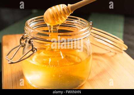 Akazien-Honig in einem Glas mit Honig-stick Stockfoto