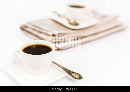 Zeitung und weißen Tasse Kaffee auf weißem Hintergrund Stockfoto