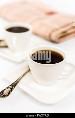 Zeitung und weißen Tasse Kaffee auf weißem Hintergrund Stockfoto