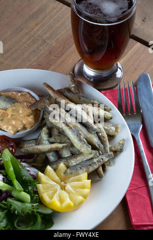 Eine Vorspeise Teller aus einem englischen Pub/Bar-Menü gebratene Sardellen und Marie Rose sauce mit einem Beilagensalat und Glas Bier/Bier. Stockfoto