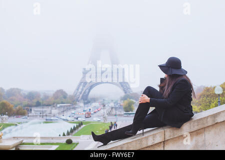 Herbst und Winter in Paris, Mode Frau Blick auf Eiffelturm in nebligen Tag, Frankreich Stockfoto