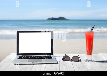 Büro am Strand, Laptop mit leeren Bildschirm, Sonnenbrille und tropischen cocktail Stockfoto