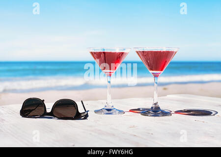 Sommer-Ferien-Konzept, zwei Cocktails und Sonnenbrillen auf dem Strand Tisch, tropischen Urlaub Stockfoto