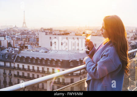 Frau genießen Panoramablick über Paris und Eiffel Turm bei Sonnenuntergang, Glas Wein oder Champagner in Luxus-Restaurant auf dem Dach halten Stockfoto