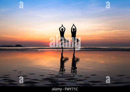 Yoga am Strand, Gruppe von Menschen, die gesunde Lebensweise praktizieren Stockfoto