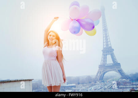 Urlaub in Paris, bunte Träume, fröhliches Mädchen mit Luftballons in der Nähe von Eiffelturm Stockfoto