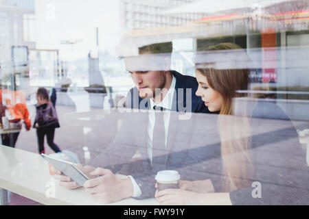 Geschäftsleute im Café auf den Bildschirm des Tablets Stockfoto