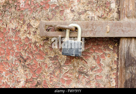 Alte rostige Vorhängeschloss auf beschädigte Holztüren Oberfläche. Stockfoto