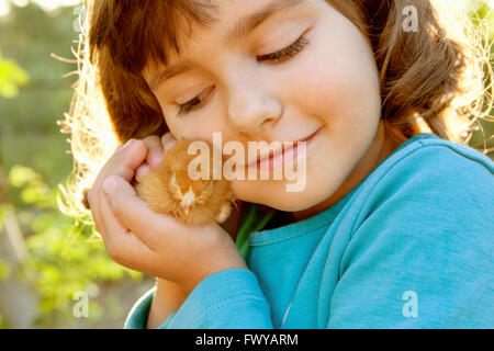 Liebevolle zärtliche Mädchen mit Huhn in Händen wie einen Schatz Stockfoto