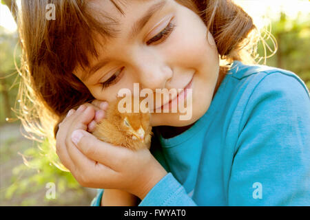 Liebevolle zärtliche Mädchen mit Huhn in Händen wie einen Schatz Stockfoto