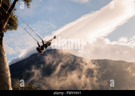 Banos, Ecuador - 25. November 2015: junge Mädchen, die eine Fahrt auf dem hohen Seil fliegen hängt an einem Baum-Haus Stockfoto