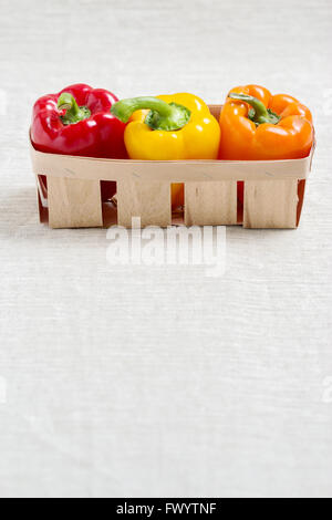 Frisches Gemüse. Drei süße Paprika in einem Korb von rot, gelb und Orange. Stockfoto