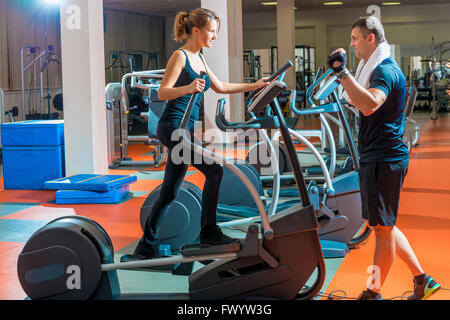 Junge schlanke Frau beschäftigt sich mit dem Simulator und trainer Stockfoto