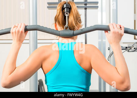 hintere Athleten engagiert am Simulator in der Turnhalle Stockfoto