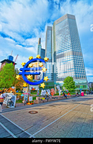 FRANKFURT, Deutschland - 29. April 2012: Euro-Denkmal und Eurotower in Frankfurt am Main. Eurotower ist Europäische Zentralbank Wolkenkratzer in Buchforst Bezirk in Frankfurt am Main. Leute aus deiner Umgebung Stockfoto