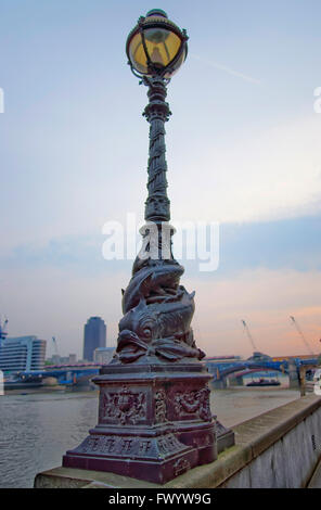 Delphin-Lampe standard am Ufer der Themse in London in England. Die Lampe hat eine Dekoration aus zwei Delphine oder störe. Stockfoto