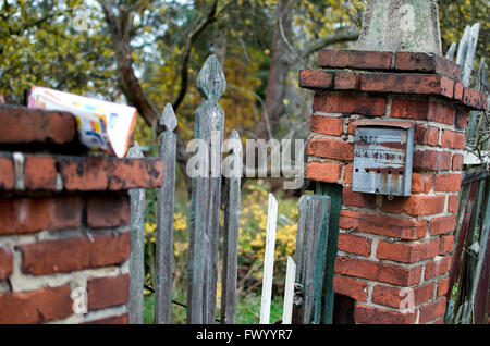 Sehr alte rostige Briefkasten auf der Backstein-Spalte. Stockfoto