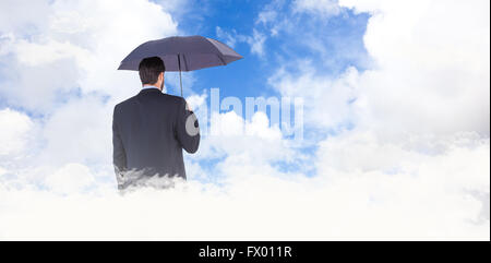 Zusammengesetztes Bild der Geschäftsfrau im Anzug hält Regenschirm Stockfoto