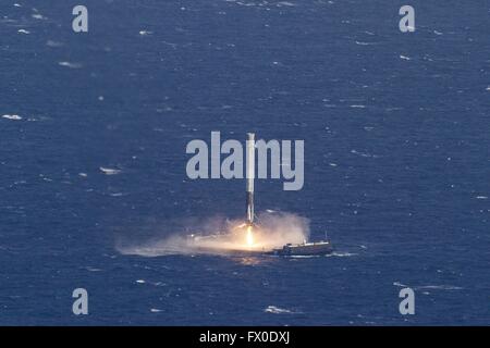 Die SpaceX Falcon 9 wiederverwendbare Rakete beginnt einen allmählichen Abstieg mit Booster-Raketen, die schwimmenden Landeplattform 8. April 2016 in den Atlantischen Ozean. Die CRS-8-Mission erfolgreich angetrieben die Dragon-Kapsel zur internationalen Raumstation ISS und dann zurück auf die Droneship zum ersten Mal. Stockfoto