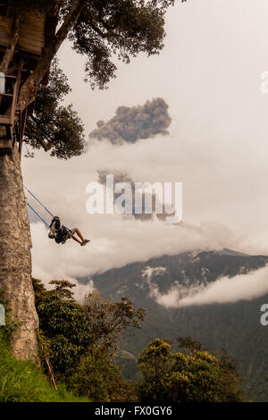 Silhouette des jungen Teenager Mann auf einer Schaukel, Casa Del Arbol, Baumhaus, Vulkan Tungurahua Explosion am März 2016 Stockfoto