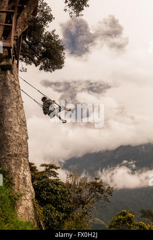 Banos De Agua Santa - 8. März 2016: glückliche Erwachsene kaukasischen Mann schwingen auf einer Schaukel In Banos De Agua Santa, Vulkan Tungurahua Stockfoto