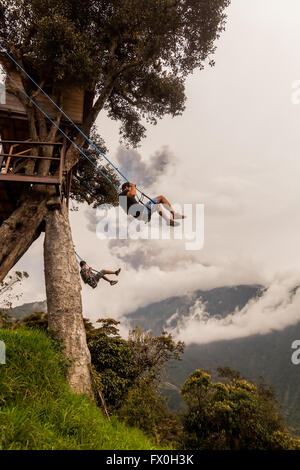 Banos De Agua Santa - 8. März 2016: Silhouette von zwei jungen Männern auf einer Schaukel In Banos De Agua Santa, Vulkan Tungurahua Stockfoto