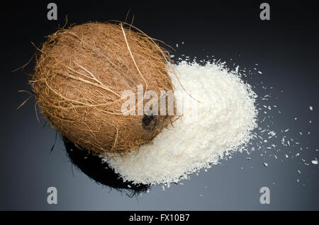 Haufen Dehydriertes Coconut und ganze Kokosnuss auf schwarzem Hintergrund isoliert. Stockfoto