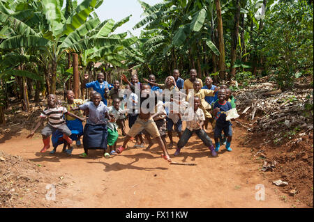 Gruppe von ruandischen Kindern eine Ballspiel auf einer staubigen Straße spielen und Spaß haben. Stockfoto