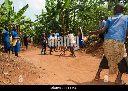 Gruppe von ruandischen Kindern eine Ballspiel auf einer staubigen Straße spielen und Spaß haben. Stockfoto