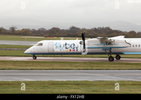 Flybe Bombardier Dash 8 Q400 Mittelstrecken-zweimotorige Passagierflugzeug (G-KKEV) des Rollens auf Manchester International Airport. Stockfoto