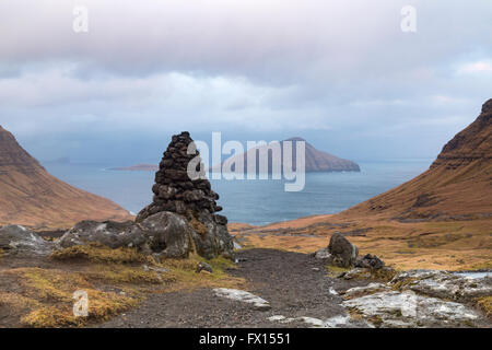 Insel Koltur Vista mit Cairn im Vordergrund von Bergen bei Sonnenaufgang auf Streymoy, Färöer, Dänemark im April - Färöer Stockfoto