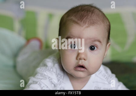 Babymädchen mit blauen Augen lernt zu krabbeln Stockfoto