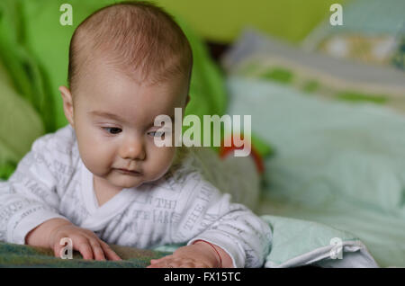 Babymädchen mit blauen Augen lernt zu krabbeln Stockfoto