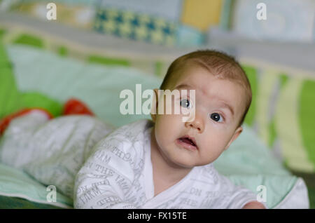 Babymädchen mit blauen Augen lernt zu krabbeln Stockfoto