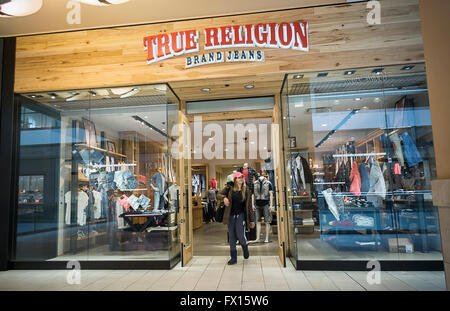 Eine True Religion Jeans Store in der Queens Center Mall in New York auf Freitag, 8. April 2016. Wahre Religion, im Besitz von TowerBrook Capital Partners LP, berichtet werden auf der Suche nach einer Beratungsunternehmen, seine Geschicke rückgängig zu machen. Geschmack der Verbraucher Weg von Jeans bis hin zu Athleisure Verschleiß wird für fallende Vermögen des Unternehmens zitiert. (© Richard B. Levine) Stockfoto