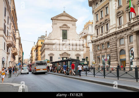 Rom - 7. August 2015: Straßenansicht von Largo Chigi mit gewöhnlichen Menschen auf eine Bushaltestelle und Chiesa di Santa Maria in Via bas Stockfoto