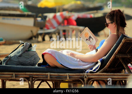 ausländische Touristen Sonnen und lesen am Patnem Beach in goa Stockfoto