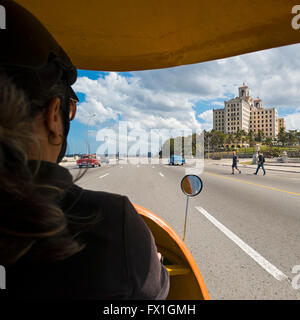 Quadratische Blick auf das Hotel National in Havanna aus einem hellen gelben Coco-Taxi, Kuba. Stockfoto