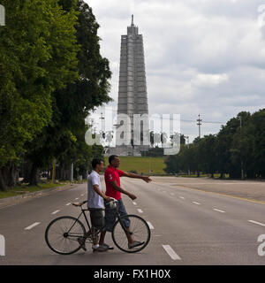 Quadratische Ansicht der lokalen Kubaner schob ein Fahrrad auf der anderen Straßenseite in der Nähe von Platz der Revolution in Havanna, Kuba. Stockfoto