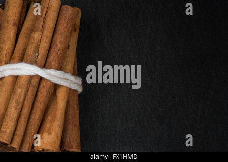 Bündel von Zimt-Sticks eng mit textfreiraum auf Schiefer Hintergrund nach rechts Stockfoto
