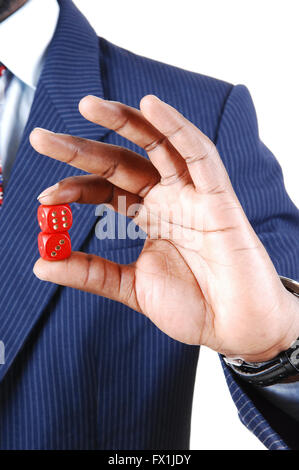 Ein schwarzer Geschäftsmann mit zwei roten Würfel in der Hand, in einem blauen Anzug steht für weißen Hintergrund isoliert. Stockfoto