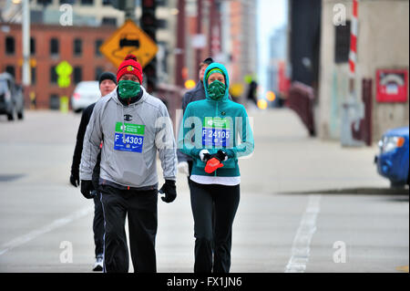 Zwei Läufer, voll für die kühlen Bedingungen, zu Fuß zum Ausgangspunkt der Shamrock Shuffle Rennen in Chicago, Illinois, USA vorbereitet. Stockfoto